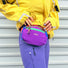 A fashionable woman wearing a purple belt bag for a City Walk, highlighting the hands-free utility.