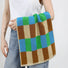 Model holding a Color Game Plaid Face Towel in blue-green, easy for gym, travel, and weekends.