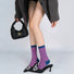 Model wearing a pair of pink houndstooth socks, ideal for everyday outfits and sneakers.
