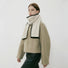 Model wearing a wool knit scarf in beige, easy for weekend styling and gifting.