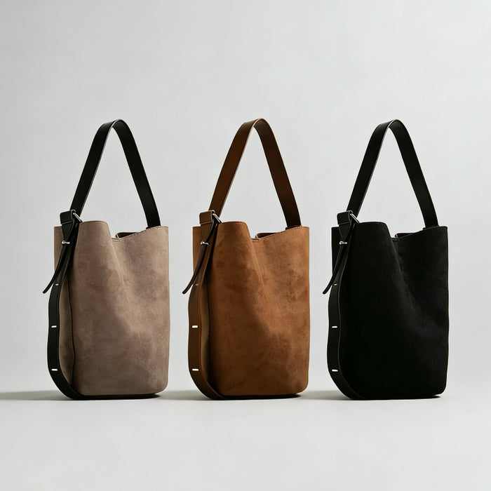 Group shot of the convertible suede bucket bag in grey, brown, and black.