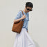 Model wearing the brown suede bag as a shoulder bag for a stylish, relaxed look.