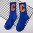 Pair of royal blue crew socks with a large orange "C" on each, made from cotton-acrylic blend.