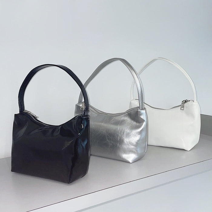Three cool patent leather shoulder bags in black, silver, and white, featuring a sleek, compact design.