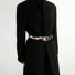 Model wearing a cow print furry belt over a black blazer; chic waist-cinching accessory perfect for office styling.