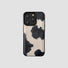 Black and white cow print leather iPhone case. Chic animal pattern with protective black edges and camera trim.