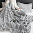 Grey polar fleece blanket with 3D wave design, minimalist neutral room decor.