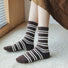 Model wearing a pair of brown striped wool socks, easy for travel days and daily comfort.