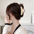 Model wearing Cream Black Border Hair Claw in curve shape, easy for workdays and special occasions.