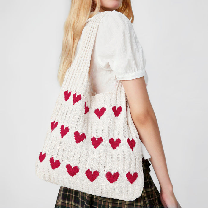 model-wearing-cream-red-heart-crochet-bag
