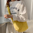 Model wearing the yellow quilted crescent bag as a front crossbody.