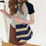 Model carrying a blue striped tote bag  as crossbody, easy for commuting and weekends.