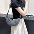 Model carrying a washed black Croissant Denim Shoulder Bag on her shoulder , great for daily carry and travel.