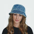 Woman wearing a wide-brim blue denim patchwork bucket hat, perfect for stylish summer sun protection.