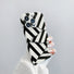 Close-up of Model holding Diagonal Stripe Case. Sleek faux leather and silicone blend with dynamic stripes.