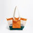 Detailed front view of the vibrant orange and green double-sided tote bag.
