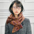 Model wearing Dual-Sided Aurora Texture Soft Scarf, a wool blend scarf with multicolored stripes in brown.