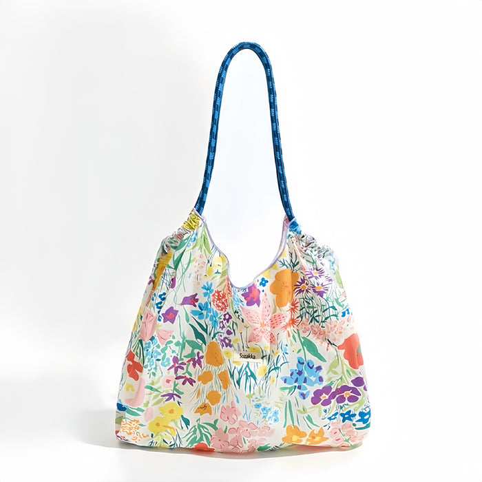 White polyester tote bag with colorful floral print and blue rope straps.