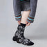 Model wearing a pair of black Floral Embroidered Socks, great for casual wear and light workouts.
