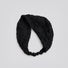Studio view of the black floral lace headband looped to show its flexible stretch construction and floral pattern.