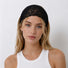 Front view of a blonde model styling the black floral lace headband as a wide hair wrap.
