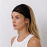 Side view of a model wearing the black lace headband folded narrower for a subtle gothic hair accessory look.
