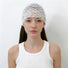 Front view of a model with long straight brown hair wearing the white floral lace headband spread wide across the crown.
