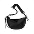 Minimalist black half-moon bag with an adjustable knotted rope strap, water-resistant material for urban utility.