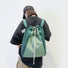 Rear view of the green 2-way bag used as a backpack, demonstrating the comfortable shoulder straps.