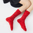 Model wearing a pair of  Fuzzy Embossed Socks in red, great for daily wear and lounging.