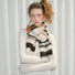 Model wearing Fuzzy wool-polyester striped scarf in earthy tones of cream, brown, green, and orange Fuzzy Nature.
