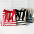 Front view of Three polyester knitted bags with geometric lines: red and white, black and white, and viridian and beige.