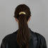 Model wearing a large Gleaming Curve Hair Cuff in gold, easy for workdays and special occasions.