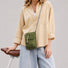 Model wearing the green grid magnetic utility bag as a crossbody pouch.