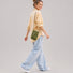 Side view of a model carrying the lightweight green ripstop utility crossbody bag on her shoulder.