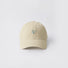 Front view of a beige cotton baseball cap with a subtle embroidered heart.