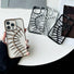 White silicone iPhone case with gold hollow fishbone. Display showing three other cases in black and silver.