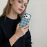 Model holding a blue jelly bubble phone case, highlighting the chunky, stylish silhouette.