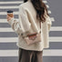 Khaki nylon mini bag worn by a model as a crossbody, paired with a white sweater.