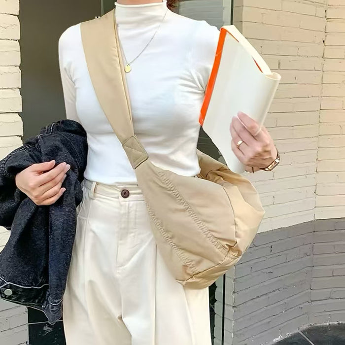 Khaki padded nylon crescent bag in a minimalist urban look, featuring a wide shoulder strap for comfort.