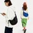 Two models wearing black and cobalt blue knotted crescent bags, showcasing the urban utility aesthetic.