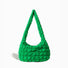 Isolated front view of the green puffy quilted crossbody bag.