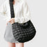 Model styling the black puffy quilted crossbody bag for a casual outfit.