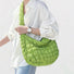 Model wearing the vibrant large green puffy crossbody bag for a casual modern look。