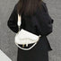 Model carrying a Threaded Saddle Bag in white as crossbody, ideal for city walks and gifting.