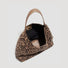Detailed view of the spacious interior and soft fabric lining of the leopard hobo bag.