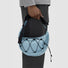 A person carrying a light blue airy nylon crescent sling bag by its adjustable strap, showcasing the bungee cord lattice.
