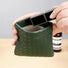 Hands opening green magnetic self-closing storage bag; woven-look pouch for quick makeup storage on the go.