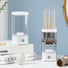 White and clear ABS automatic makeup brush cleaner with brushes inside, next to a similar empty unit.