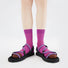 Model wearing a pair of Matrix Stripe Socks in magenta, ideal for workouts and commuting.